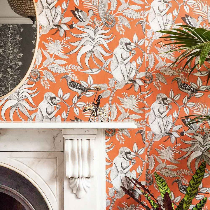 Cole & Son Savuti Wallpaper in Tangerine featured on the chimney breast of a living room wall