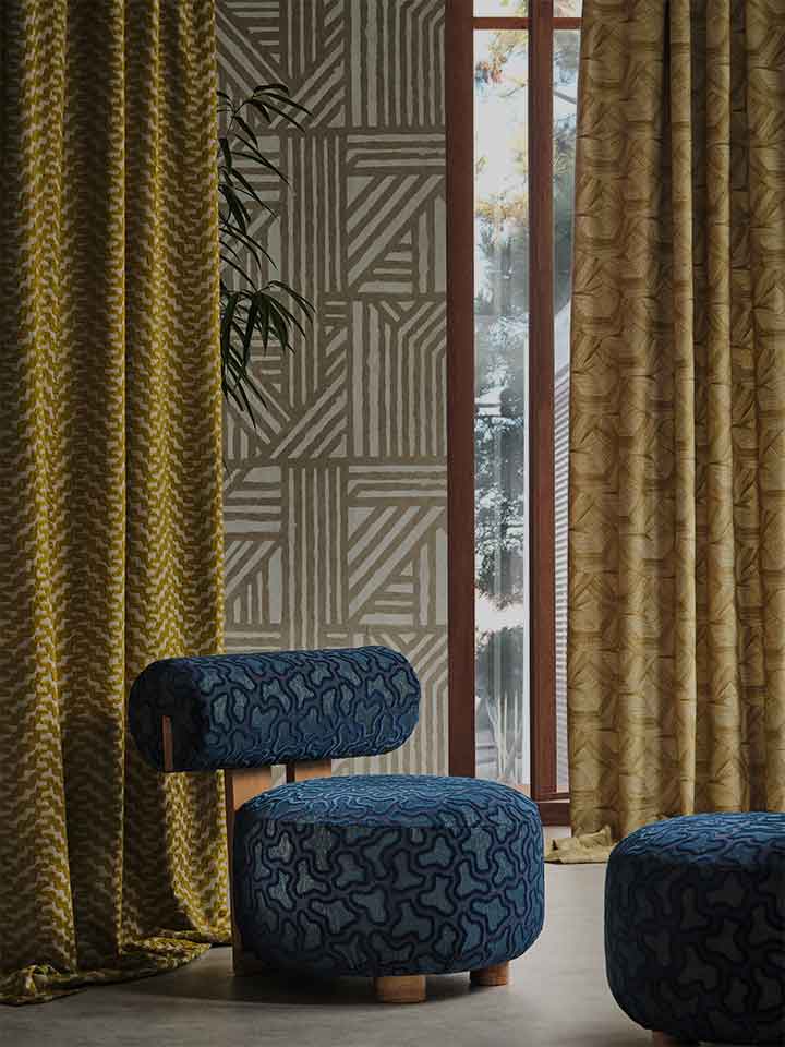 Blue patterned ottomans against a geometrically patterned curtain